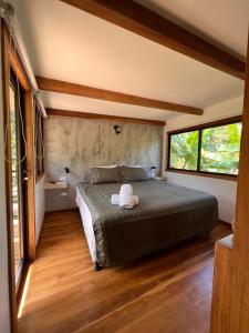 a bedroom with a bed and two windows at Feeling Trees Jungle Lodge in Cabuya