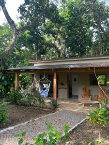 una casa con una hamaca en el porche en Feeling Trees Jungle Lodge, en Cabuya