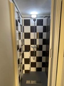 uma casa de banho com um chuveiro com azulejos pretos e brancos em Ommi Hostel em St. Julian's