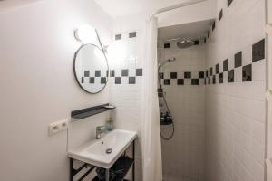 Baño blanco con lavabo y espejo en Superb 3 Bedroom & 3 Bathroom Duplex In Brussels City Centre, en Bruselas