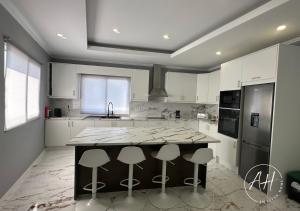 a kitchen with a large island with bar stools at Amazing Home in Ponta Garça