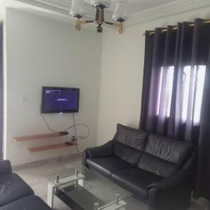 a living room with a couch and a tv at RÉSIDENCE 2k in Yaoundé