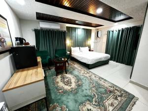a hotel room with a bed and a table at Shelton's Suites Bhurban in Bhurban
