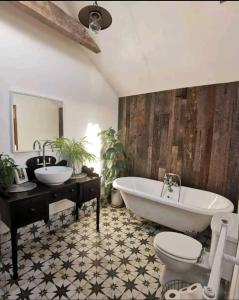 a bathroom with a tub and a toilet and a sink at The Carton Store Loft Apt in Cork