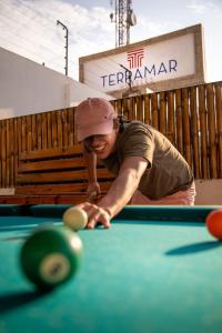 Ein Mann, der sich über einen Billardtisch lehnt mit einem Ball in der Unterkunft Terramar Hoteles in Crucita