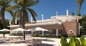 ein Gebäude mit Tischen, Sonnenschirmen und Palmen in der Unterkunft Princess Senses The Mangrove Resort - Adults Only in Green Island