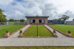 uma casa de pedra com um jardim em frente em 'The Stables' (Tigh Mary) em Galway