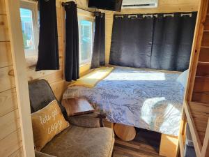 a bedroom in a tiny house with a bed and a chair at Tiny Home By The Beach in Blaine