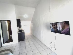 ein Bad mit einem an der Wand hängenden TV in der Unterkunft Área Consulado y CAS 1 persona - D8 in Nuevo Laredo