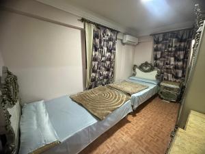 a small bedroom with a bed and a window at Apartment Sedi Beshr in Alexandria