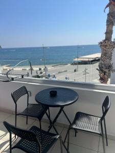 a table and chairs on a balcony with the ocean at Sea La Vie #1 - Luxury Seaview apartment in Paphos City