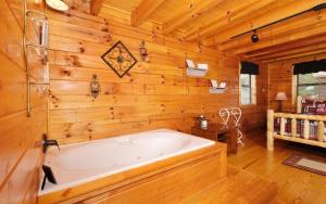 a large white tub in a room with wooden walls at Heavenly Haze Hideaway in Sevierville +17 photos