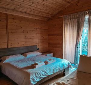 a bedroom with a bed in a log cabin at BioFarm Gramsh 