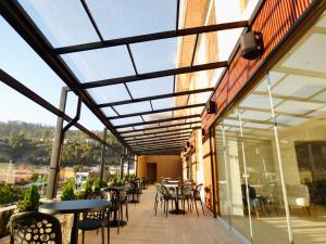a balcony with tables and chairs and windows at Muña Hotel Andahuaylas in Andahuaylas