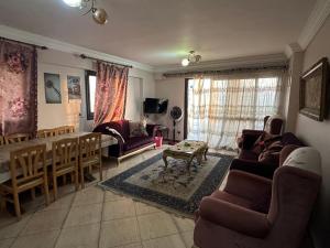Apartment Sedi Beshr في الإسكندرية: غرفة معيشة مع أريكة وطاولة