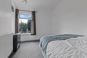 a bedroom with a bed and a window at Modern 3-Bed Terraced House in Sutton-In-Ashfield in Skegby
