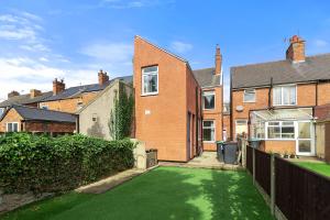 una casa con césped verde en el patio en Modern 3-Bed Terraced House in Sutton-In-Ashfield en Skegby