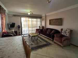 a living room with a couch and chairs and a table at Apartment Sedi Beshr in Alexandria