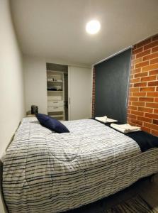 ein Schlafzimmer mit einem großen Bett mit Ziegelwand in der Unterkunft Luxury Apartment, 1110 Z.4 in Guatemala