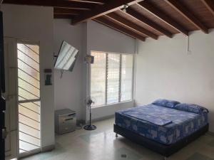 1 dormitorio con 1 cama en una habitación con ventanas en Metamorfosis, en Medellín