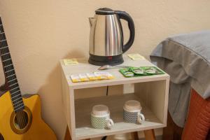 a tea kettle on a table next to a guitar at Hostal Encounter Guanajuato in Guanajuato