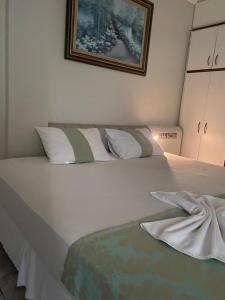 a bedroom with a large white bed with white pillows at Águas Palace Hotel in Petrolina