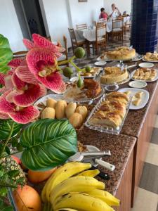 a buffet line with food and bananas and other foods at Águas Palace Hotel in Petrolina