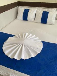 a white bed with blue and white sheets and pillows at Águas Palace Hotel in Petrolina