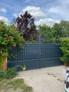 a black gate in a driveway with flowers at Le Val de Nodicia in Montlivault