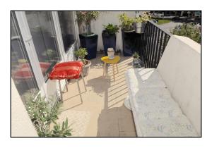 a balcony with a bench and a table and chairs at chambre et salle de bain privée chez l habitant Nina in Champigny-sur-Marne