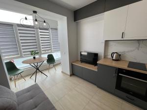 eine Küche und ein Wohnzimmer mit einem Tisch und Stühlen in der Unterkunft Apartment Premium in center in Iwano-Frankiwsk