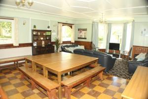 ein Wohnzimmer mit einem Holztisch und Stühlen in der Unterkunft Lledr House Hostel near two Zip World sites in Dolwyddelan