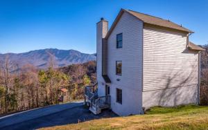 a house on the side of a road with mountains in the background at Sky High in Gatlinburg