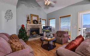 a living room with a christmas tree and a fireplace at Sky High in Gatlinburg