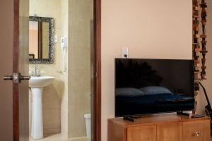 a bathroom with a flat screen tv on a dresser at Hostal Encounter Guanajuato in Guanajuato
