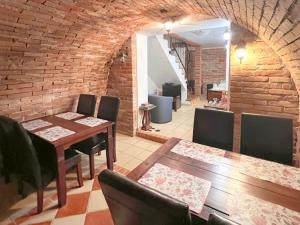 a dining room with a table and chairs and a brick wall at Sommelierka in Valtice