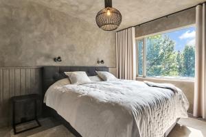 een slaapkamer met een groot bed en een raam bij Hvoll Villa in Ölfus