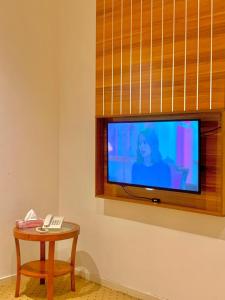 a room with a television and a table with a phone at مكان ينبع الجديد للشقق الفندقية in Yanbu