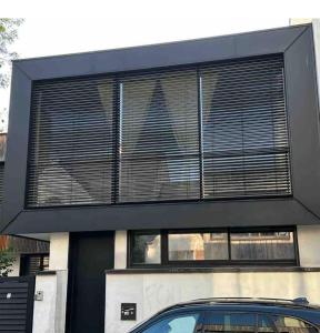een zwart huis met een auto ervoor geparkeerd bij Maison à 5 minutes de Paris et idéal Disneyland in Montreuil