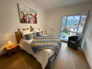 ein Schlafzimmer mit einem Bett, einem Stuhl und einem Fenster in der Unterkunft Appartement au pied du Mont-Blanc 2! in Sallanches