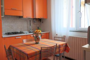 een keuken met een tafel met een vaas met fruit erop bij Bilocale accogliente tra Como e Milano in Saronno