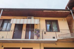 een geel gebouw met een balkon en een raam bij Bilocale accogliente tra Como e Milano in Saronno