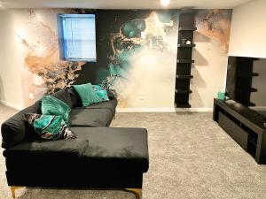 a living room with a couch in front of a wall at 1 Bed 1 Bath Basement Apartment with Private Entrance in Baltimore