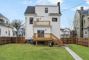 a large white house with a wooden deck in a yard at 1 Bedroom 1 Bathroom Apartment with Private Entrance in Baltimore