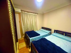 two beds in a room with a window at Clara Apartment in Alexandria