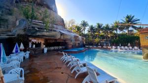 カルダス・ノバスにあるHotel Spazzio diRoma GRATIS entrada Acqua e Splash Caldas novasのリゾートのプール(白い椅子、スイミングプール付)