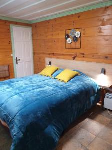 1 dormitorio con 1 cama grande y pared de madera en La Campierelle, en Salazie
