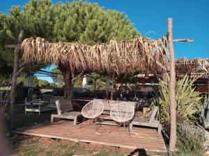 eine Holzterrasse mit zwei Stühlen und einem Strohschirm in der Unterkunft Sole 1 in Novigrad Istria