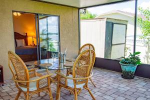 a patio with a table and chairs and a bed at Lake Howard Hideway in Winter Haven