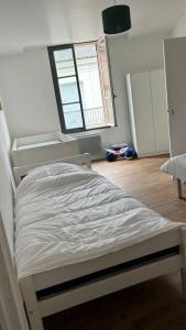 uma cama branca num quarto com uma janela em Appartement cœur de ville em Châtillon-sur-Indre